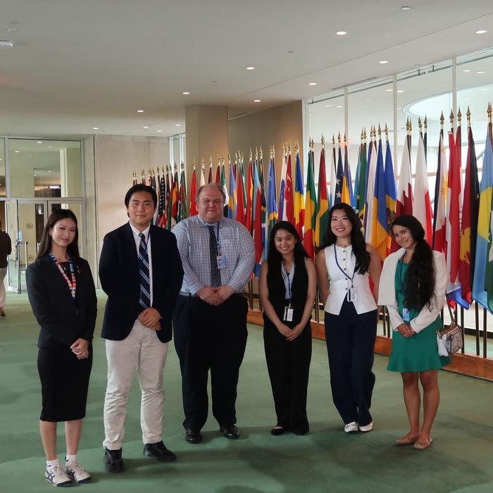 With fellow delegates by the flags at UN Headquarters